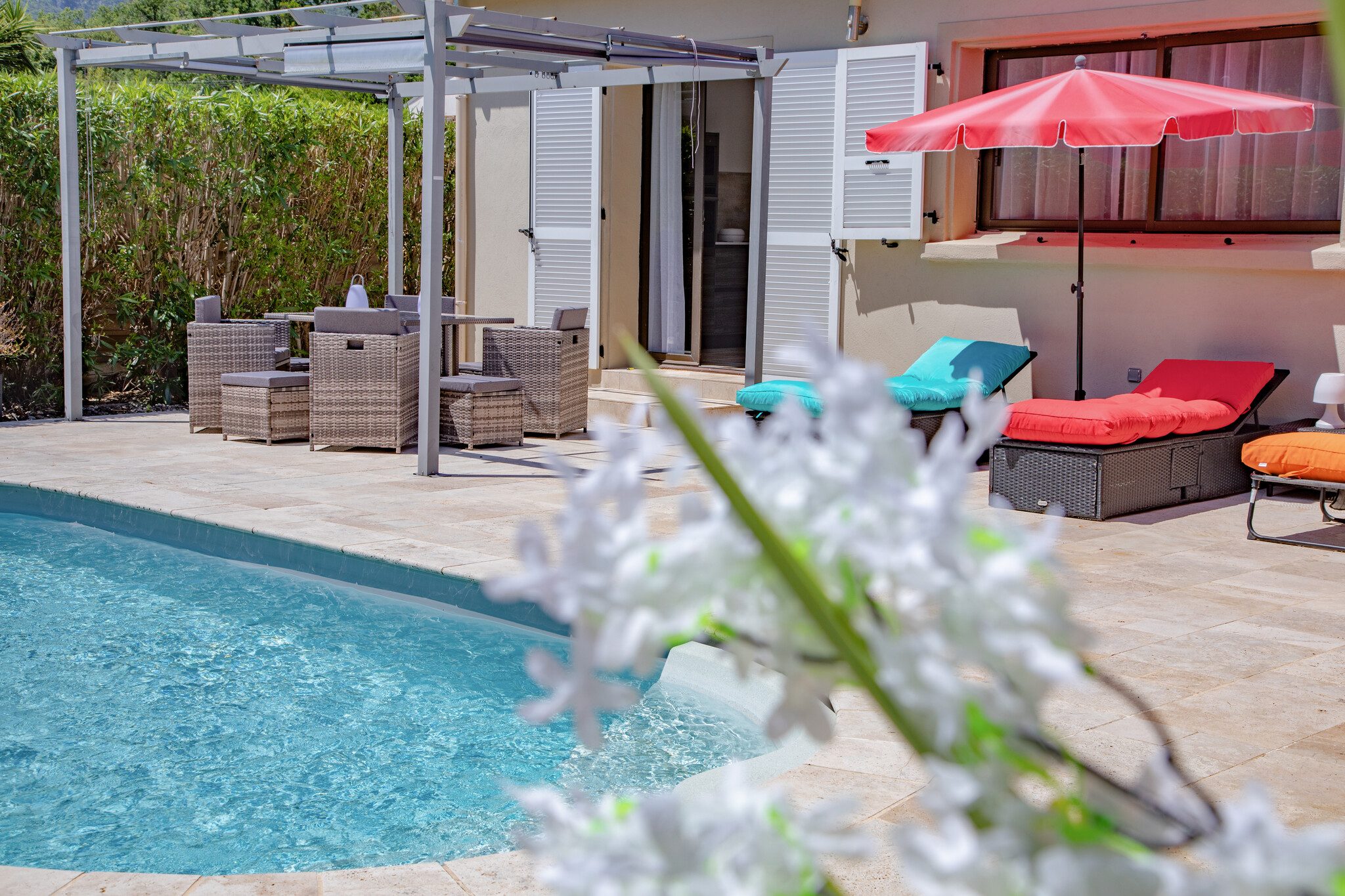 Piscina e terrazza arredata nel giardino recintato di A Casa Serena, con lettini e pergola